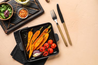 Lezzetli fırınlanmış sebzeli fırın tabağı ve renkli çatal bıçak takımı.