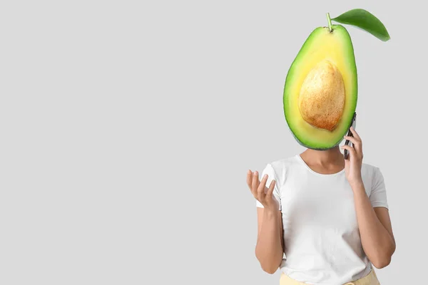 Young Woman Fresh Avocado Instead Her Head Mobile Phone Grey —  Fotos de Stock