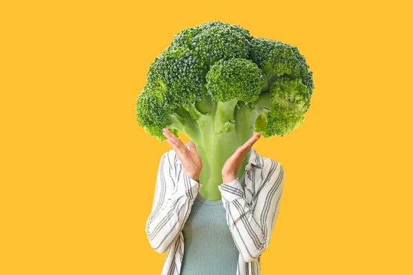 Young Woman Fresh Broccoli Cabbage Instead Her Head Yellow Background — стоковое фото