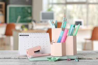 Sınıftaki masanın üzerinde okul kırtasiyesi var.