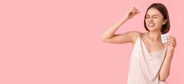 Pembe arka planda sakız çiğneyen komik bir genç kadın.