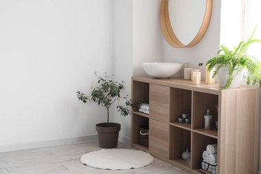 Lavabosu ve banyo aksesuarları olan ahşap raf ünitesi.