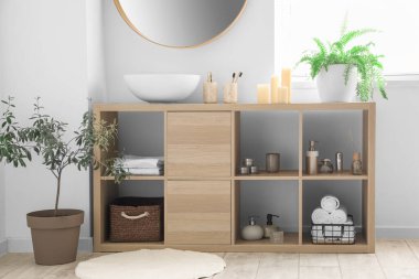 Lavabosu ve banyo aksesuarları olan ahşap raf ünitesi.