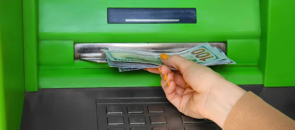 Woman withdrawing money from ATM, closeup