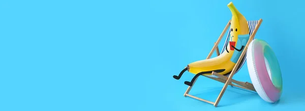 Funny banana relaxing on deck chair against blue background with space for text