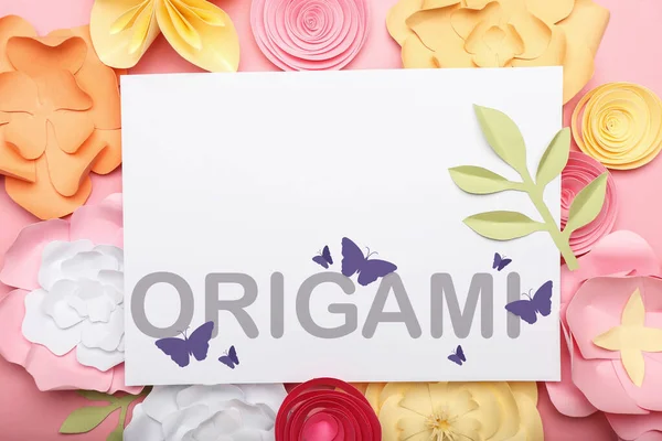 Beautiful handmade paper flowers and card with word ORIGAMI on pink background