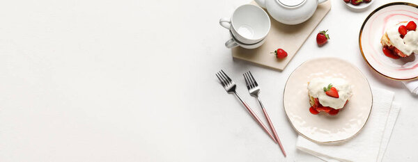 Plates with strawberry cinnamon rolls and cream on white background with space for text