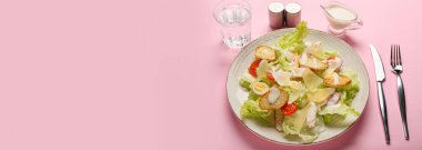 Pembe arka planda taze Sezar salatası ve metin için yer var.