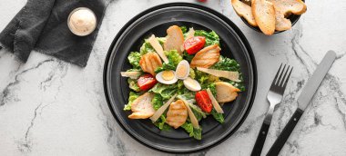 Hafif arka planda lezzetli Sezar salatası tabağı, üst manzara.