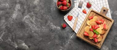 Lezzetli mini krepler ve gri arka planda çilekli kompozisyon ve metin için boşluk