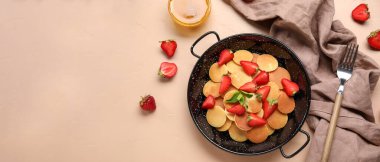 Bej arka planda mini krep kızartma tavası ve çilekli kompozisyon ve metin için boşluk