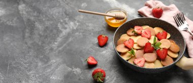 Mini krep tavası ve gri zemin üzerinde çilek ve metin için yer.