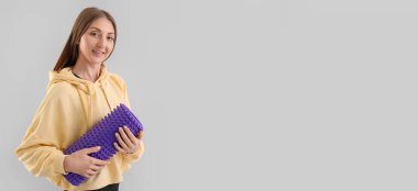 Açık arkaplanda köpük silindirli, metin için yeri olan genç bir kadın