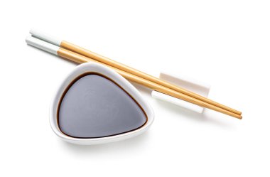 Beyaz arka planda soya sosu ve çubuklar Kase