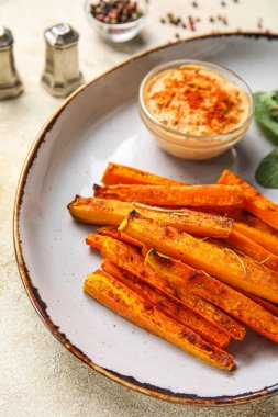 Tabak dolusu lezzetli fırında havuç ve sos, yakın plan.