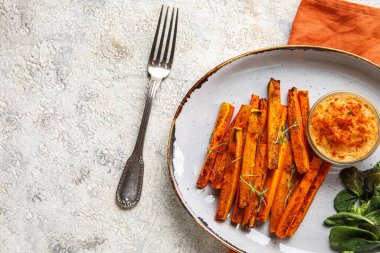 Hafif arkaplanda lezzetli havuç, sos ve çatal tabağı.