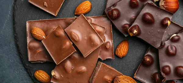 Pieces Tasty Chocolate Hazelnuts Almonds Dark Table Top View — Stock Photo, Image