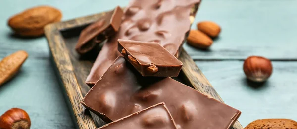 Pieces Tasty Milk Chocolate Hazelnuts Wooden Table Closeup — Stock Photo, Image