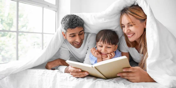 Happy Parents Reading Book Little Son Bed — Foto Stock