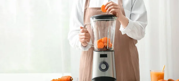 Woman Putting Cut Carrot Blender Kitchen — стоковое фото
