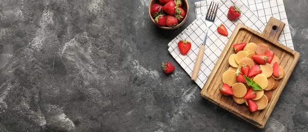 Lezzetli mini krepler ve gri arka planda çilekli kompozisyon ve metin için boşluk