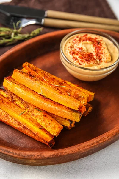 Tabak dolusu lezzetli fırında havuç ve sos, yakın plan.