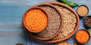 Mavi ahşap arka planda farklı çiğ mercimek