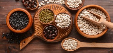 Different legumes on wooden background, top view