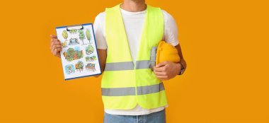 Young male landscape designer with new project on yellow background