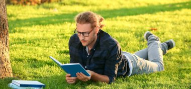 Yeşil Park 'ta kitap okuyan yakışıklı adam.