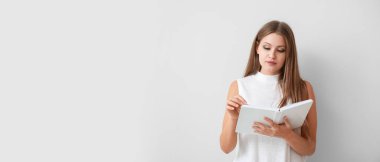 Açık arkaplan üzerine kitap okuyan genç ve güzel bir kadın.