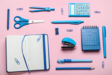 Pembe arka planda farklı kırtasiye malzemesi olan zımba.