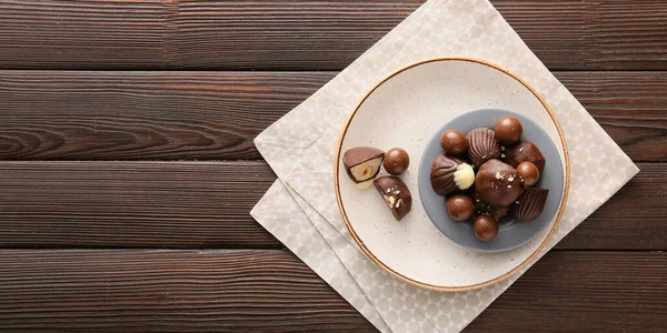 Plate Tasty Chocolate Candies Nuts Wooden Table Top View —  Fotos de Stock