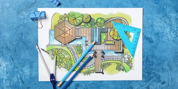 Landscape designer\'s plan with stationery on blue background, top view