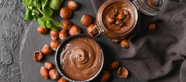 Bowl Jar Tasty Chocolate Paste Hazelnuts Dark Background Top View — Stock Photo, Image