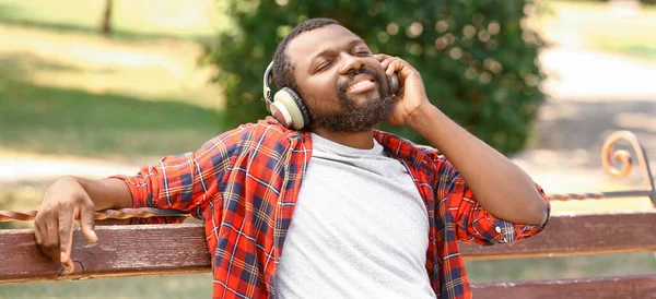 Afrikai Amerikai Férfi Zenét Hallgat Miközben Pihen Padon Parkban — Stock Fotó