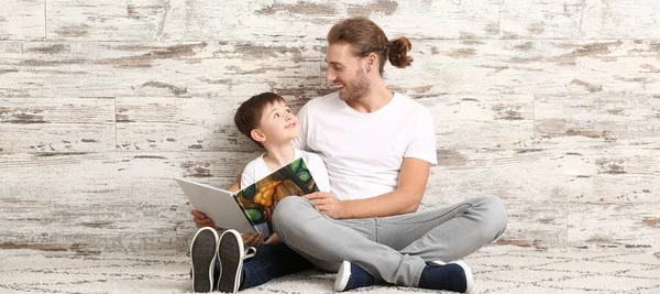 Far Och Hans Son Läser Bok Nära Trävägg — Stockfoto