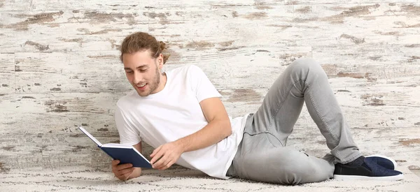 Knappe Man Leesboek Buurt Van Houten Muur — Stockfoto