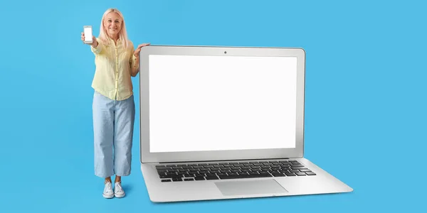 Mature Woman Smartphone Big Laptop Blue Background — Stock fotografie