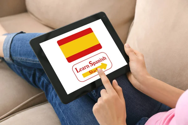 Woman with tablet computer studying Spanish at home