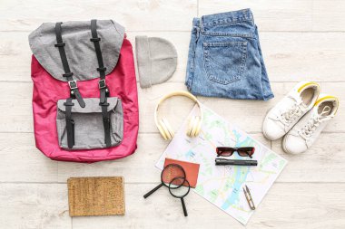 Beyaz ahşap arka planda şehir haritasıyla seyahat etmek için aksesuarlar