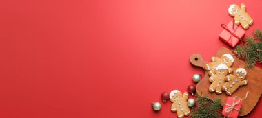 Lezzetli zencefilli kurabiye ve kırmızı zemin üzerinde Noel süslemesi ve metin için yer var.