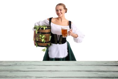 Güzel Ekim Festivali garsonu beyaz arka planda ahşap masanın yanında bira içiyor.