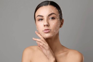 Gri arka planda sağlıklı cilde sahip güzel bir genç kadının portresi.