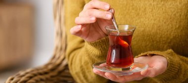 Evde Türk çayı içen kadın, yakın plan.