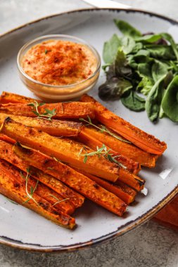 Lezzetli fırınlanmış havuç ve sos tabağı.