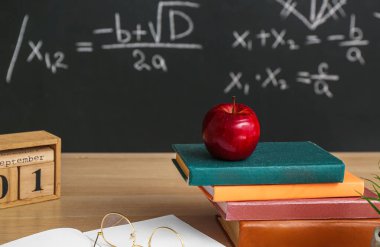 1 Eylül tarihli küp takvimi, Elma, kitap ve gözlük kara tahtanın yanındaki masada.