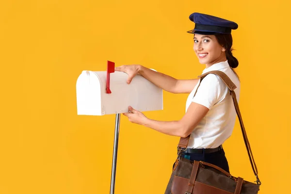 Young Postwoman Mailbox Yellow Background — стоковое фото