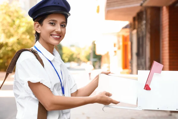 Young Postwoman Putting Letters Mailbox Outdoors — Stock Photo, Image