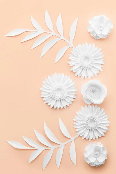 Composition with different origami flowers and leaves on pink background